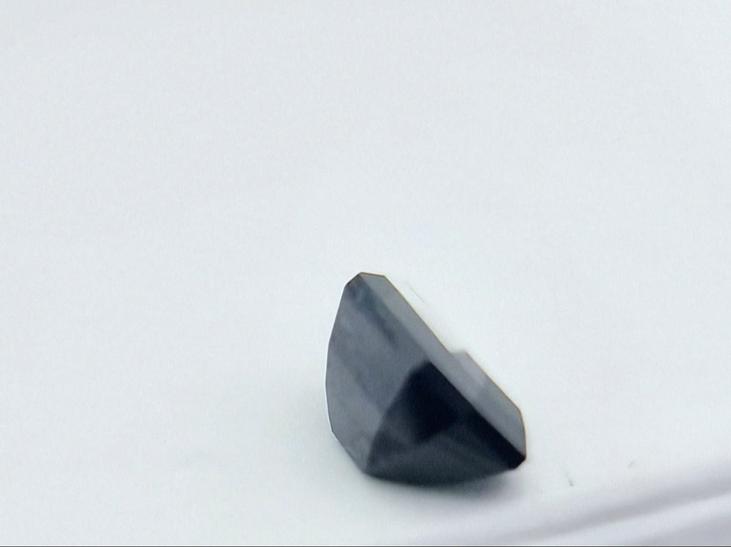 Side view of 1.84 ctw rectangular greenish blue sapphire showing its depth and precision cut, perfect for collectors and custom jewelry.