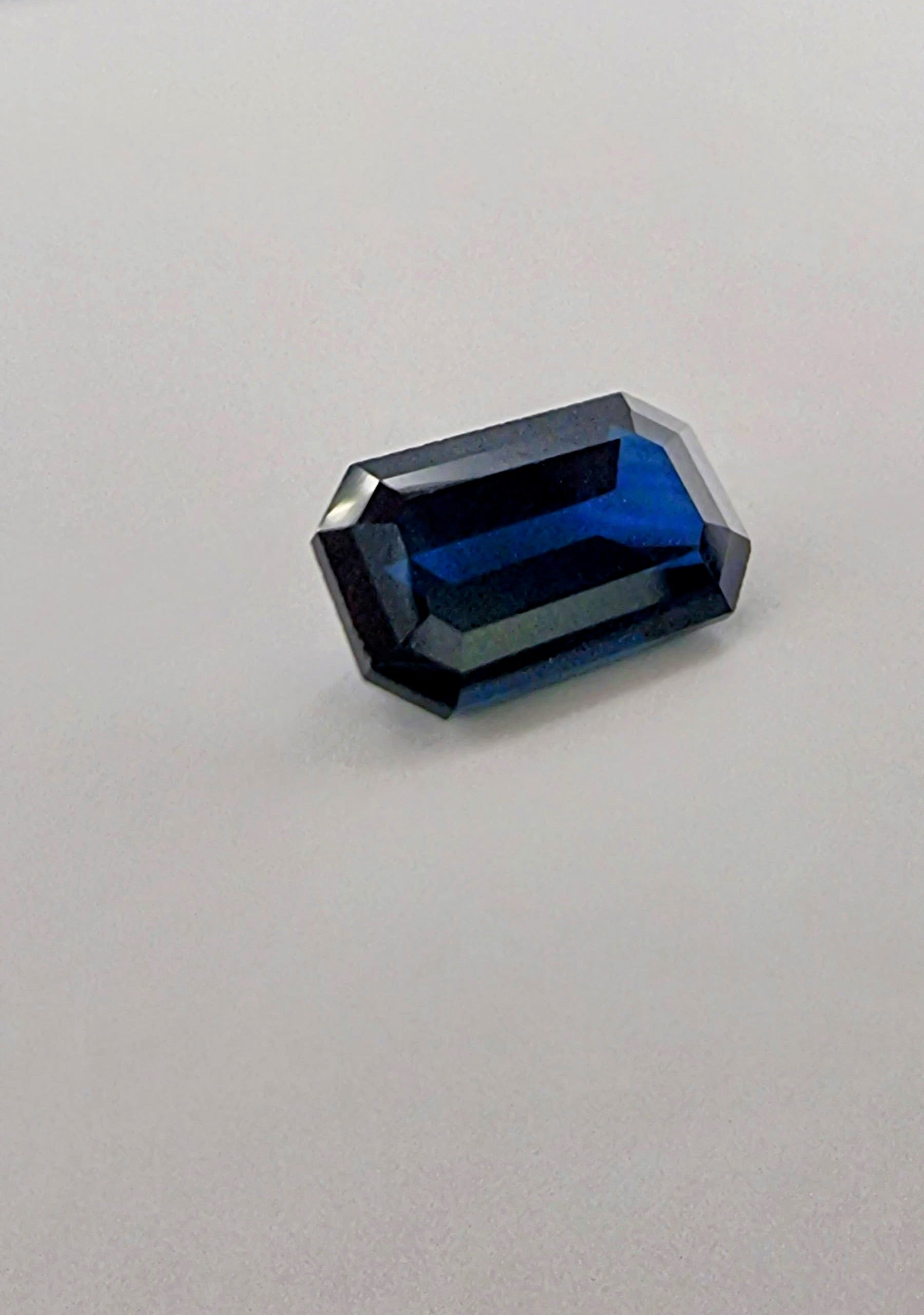 2.1ct rectangular cut dark blue natural sapphire gemstone with sharp facets and deep luster, ideal for collectors and jewelry making.