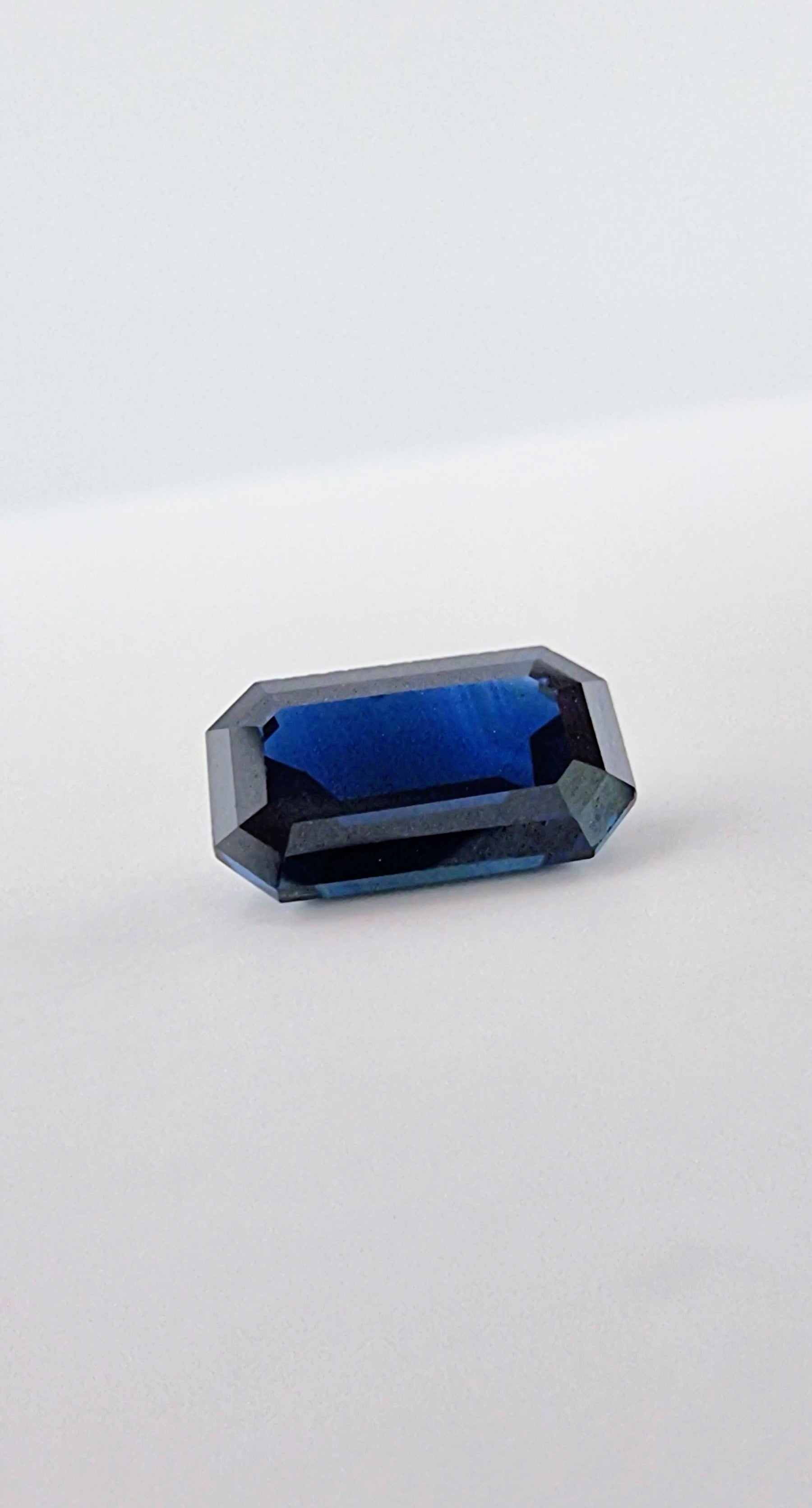 2.1ct rectangular cut dark blue natural sapphire gemstone with vivid blue tones and clean edges, perfect for fine jewelry or collections.