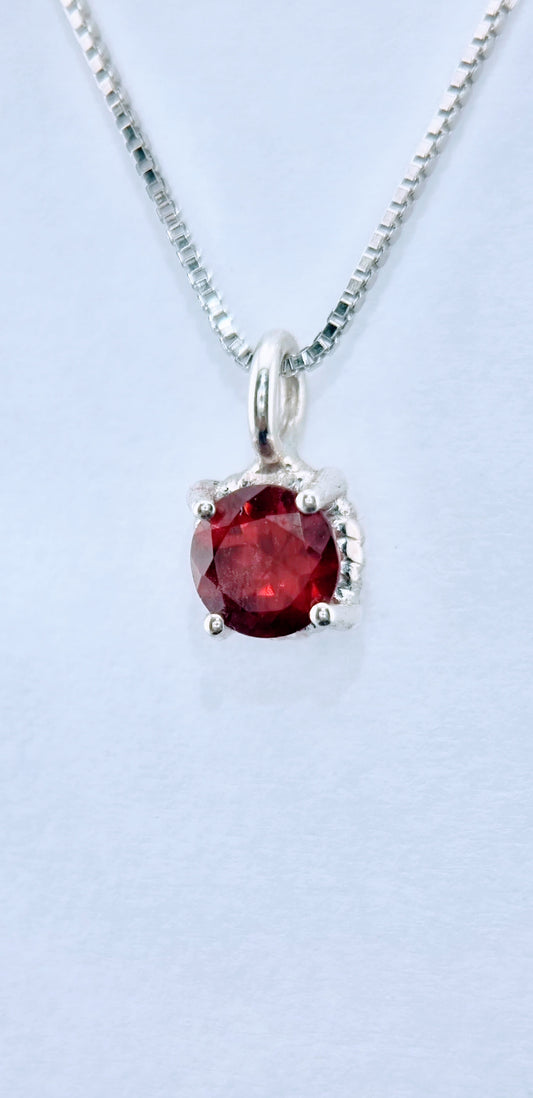 Close-up of Garnet Pendant Sterling Silver - Twist Design showing deep red garnet and intricate silver twist detail on Italian chain.