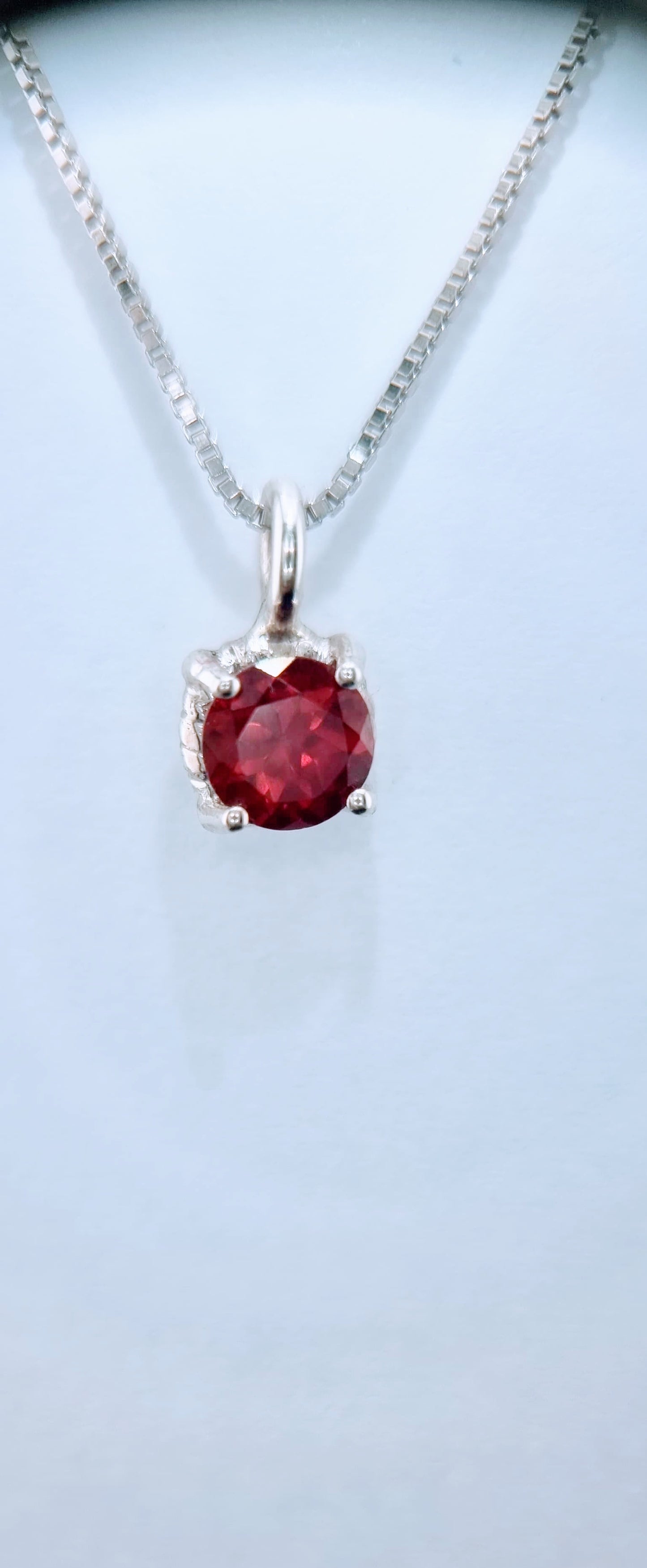 Front view of Garnet Pendant Sterling Silver - Twist Design with vibrant 6mm garnet and polished sterling silver setting on box chain.