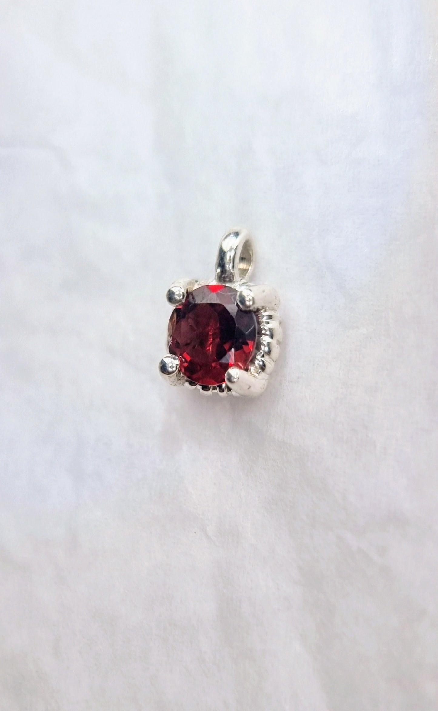 Side view of Garnet Pendant Sterling Silver - Twist Design emphasizing the deep red garnet and textured silver twist setting.