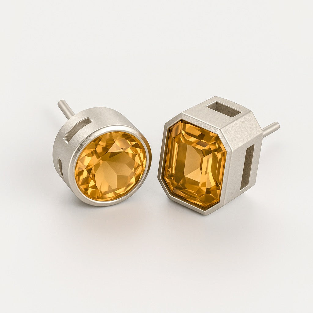Pair of citrine stud earrings with mixed cuts in geometric sterling silver cage settings, featuring round and emerald-cut bezel-set stones.