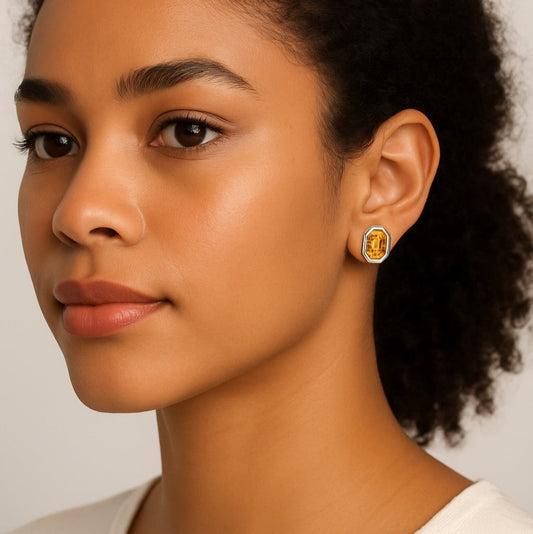 Model wearing citrine stud earrings with geometric sterling silver cage design, showcasing mismatched round and emerald-cut citrine stones.