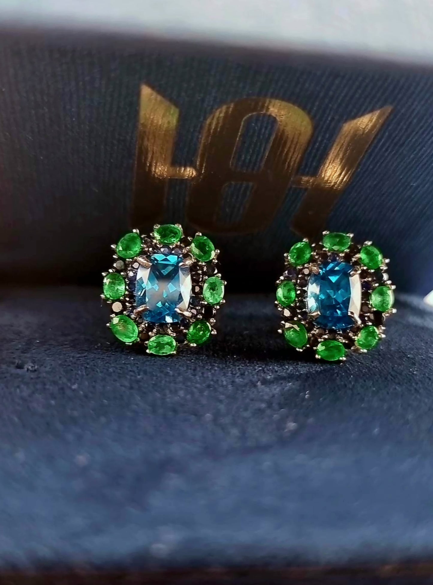 Natural Topaz Emerald & Sapphire Platinum Earrings displayed in a luxury box, highlighting the vibrant gemstone colors and fine craftsmanship.