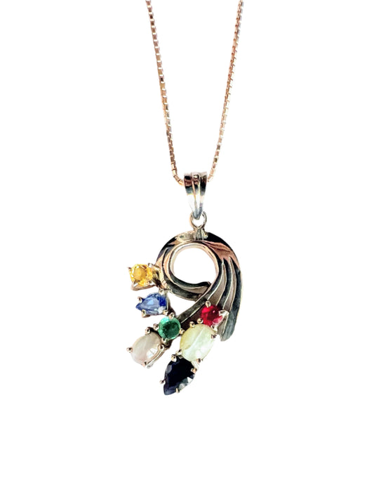 Multigem Swirling Infinity Pendant Necklace featuring ruby, sapphires, emerald, and cat's-eyes in a floral motif on a silver chain. Elegant fine jewelry for luxury fashion.