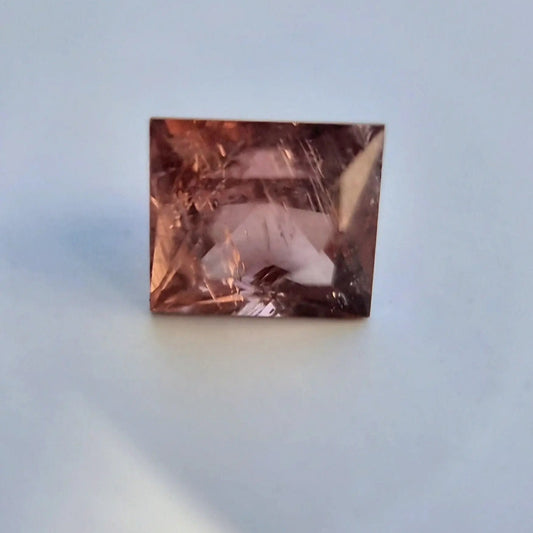 Loose 5.13 carat red square cut tourmaline showing internal clarity and unique autumn tone, perfect for gemstone enthusiasts.