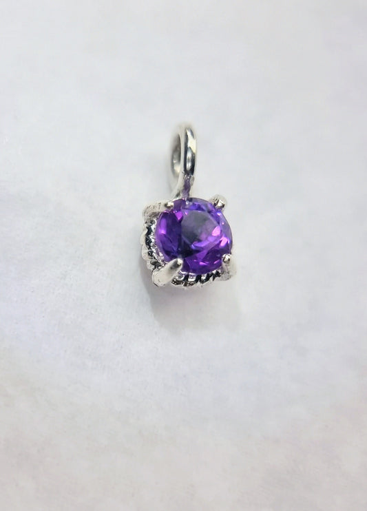 Close-up of the Dainty 6mm Round Amethyst Twist Pendant in Sterling Silver, showcasing the gemstone's vibrant purple hue and detailed setting.