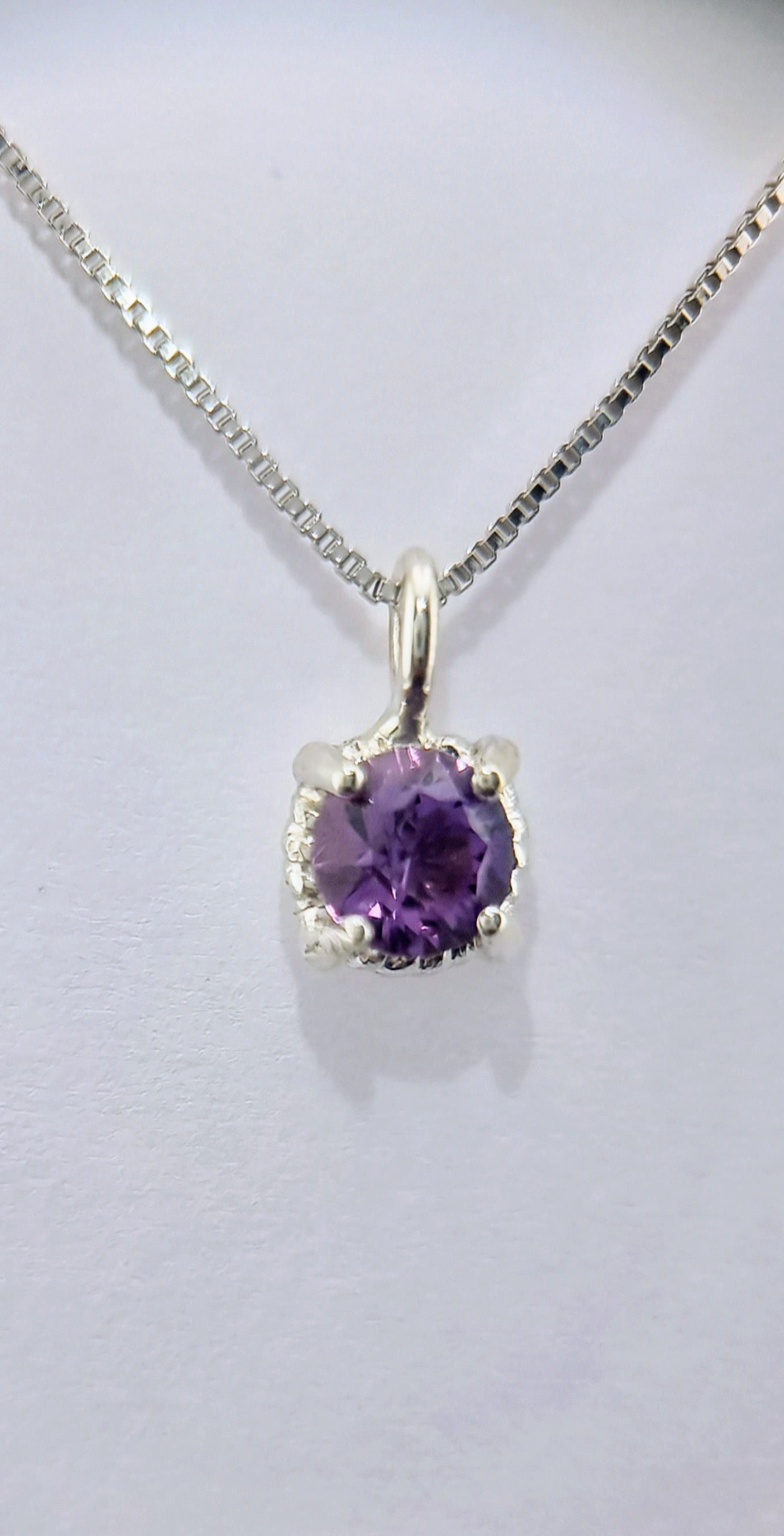 Front view of the Amethyst Twist Pendant in Sterling Silver, featuring a natural 6mm purple gemstone on a polished Italian chain.