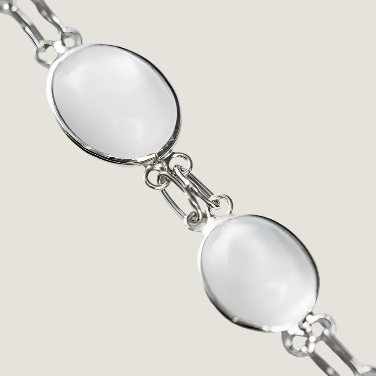 Close-up of a 13ctw cabochon moonstone link bracelet showcasing its luminous white gemstones and intricate silver detailing.