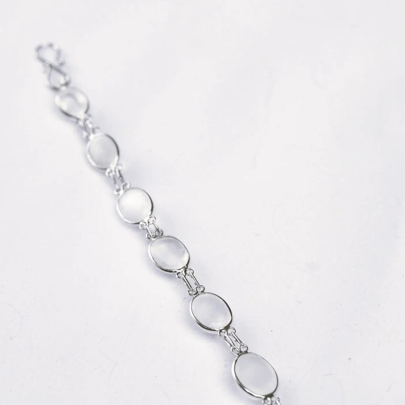 Minimalist 13ctw cabochon moonstone tennis bracelet with silver links, offering a luminous and elegant accessory for any outfit.