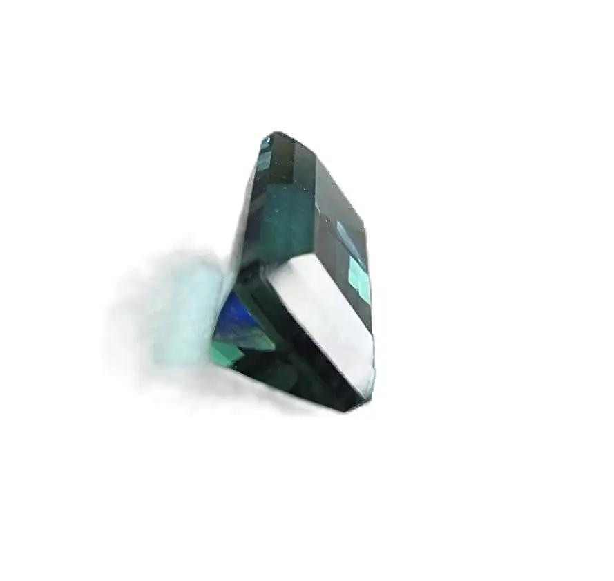 Side view of 1.20ct emerald cut blue indicolite tourmaline gemstone, highlighting its precise faceting and deep blue-green saturation.