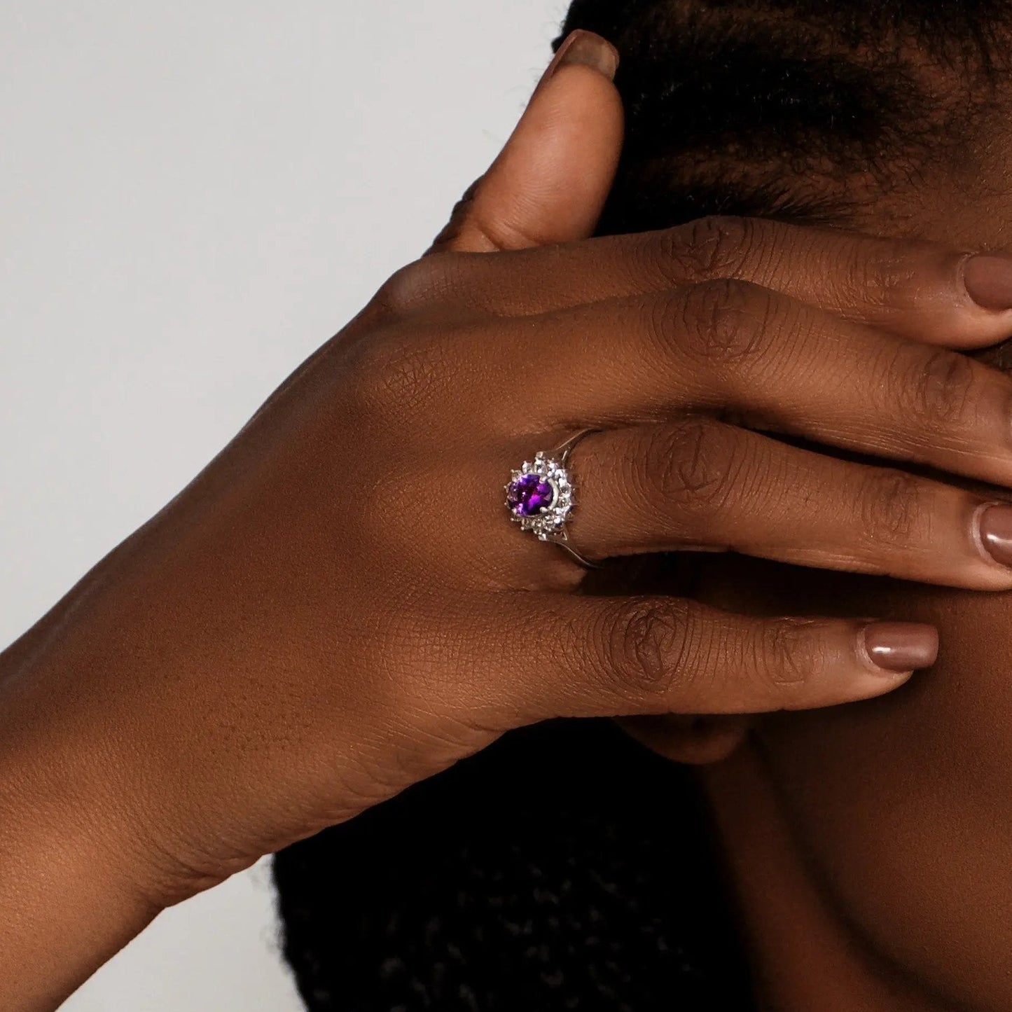Close-up of a model wearing a 2.0ct oval purple amethyst and white zircon ring, emphasizing its dazzling gemstone and sophisticated style.