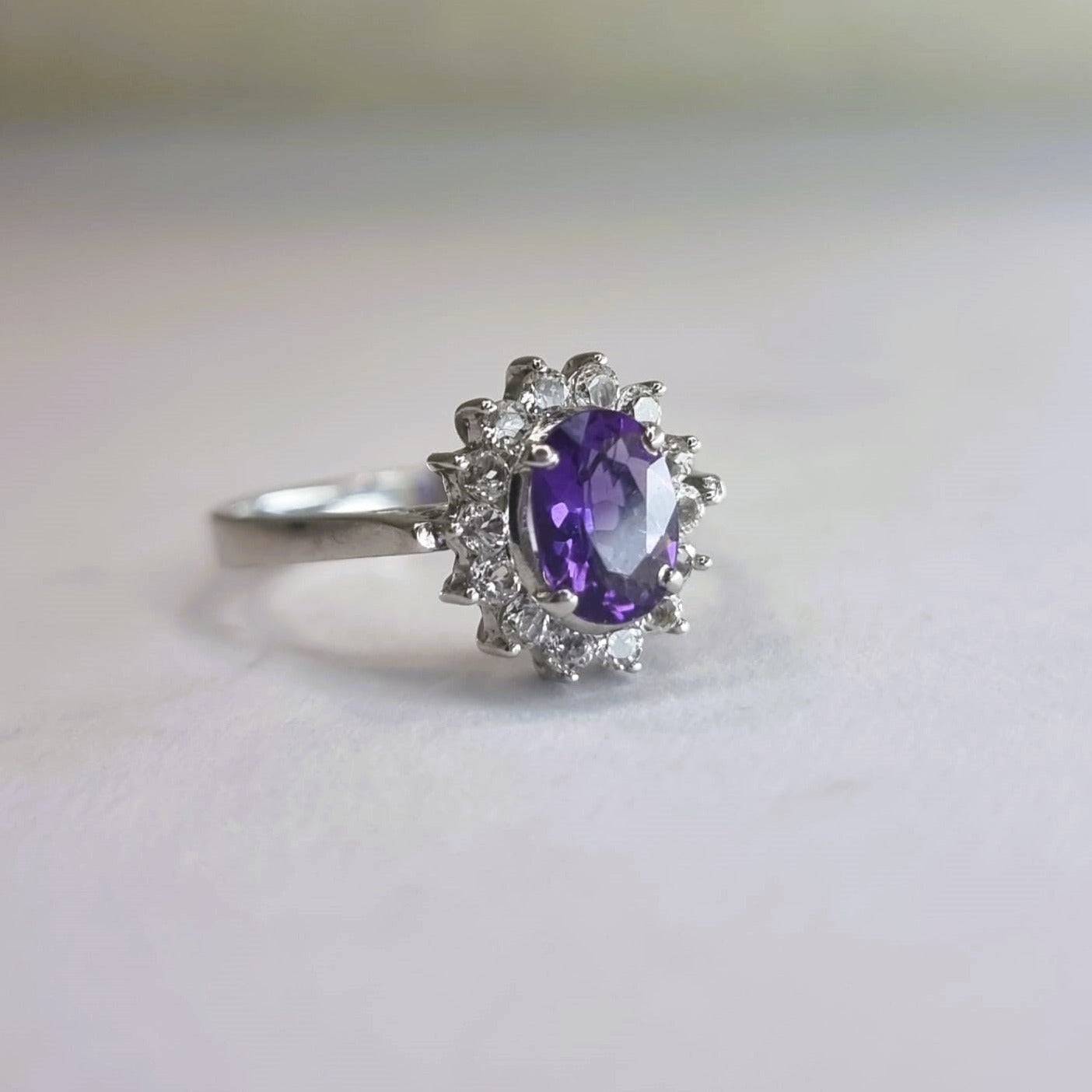 Side view of a 2.0ct oval purple amethyst and white zircon ring, highlighting its intricate setting and platinum-coated sterling silver band.