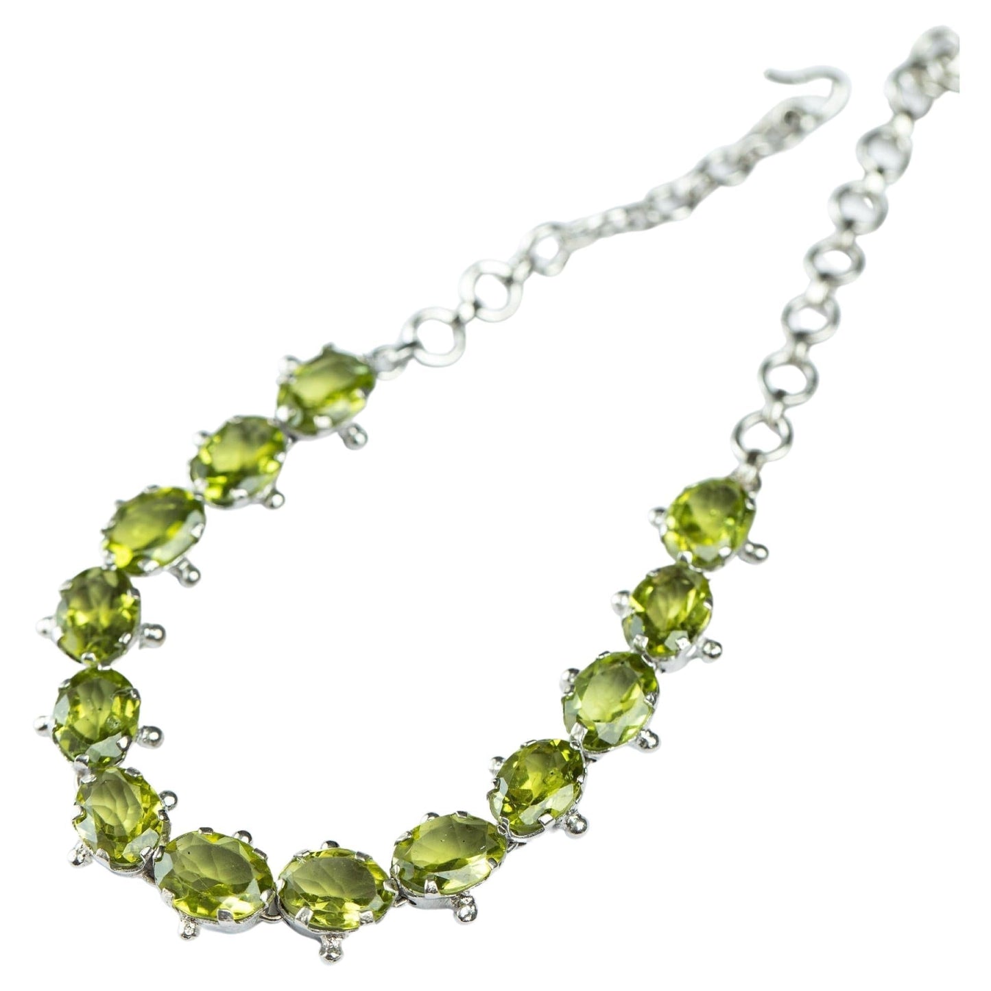 13ctw Mint Green Peridot Tennis Bracelet with oval-cut gemstones set in sterling silver. Adjustable chain for a perfect fit, ideal for elegant wear.