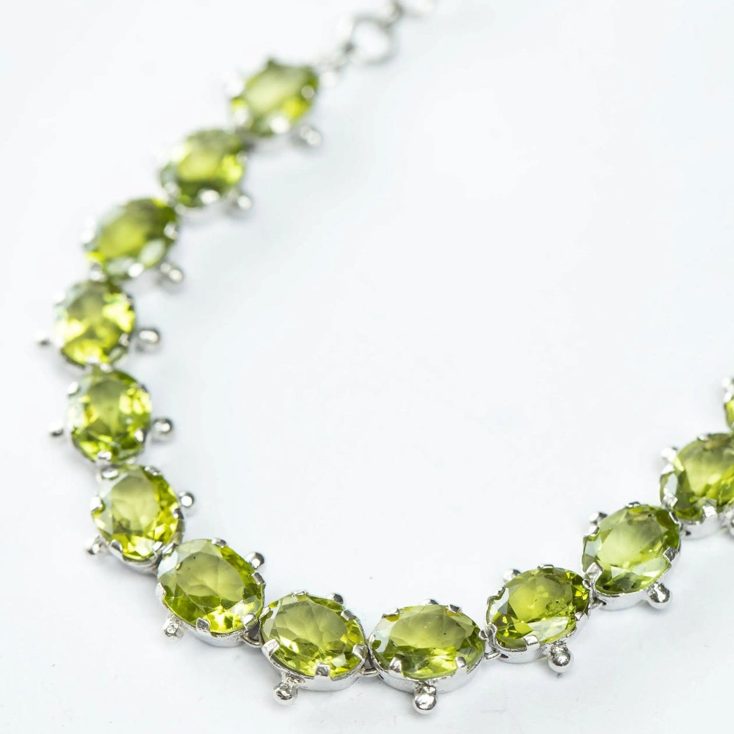 Detailed view of 13ctw Mint Green Peridot Tennis Bracelet with shimmering gemstones. A stunning sterling silver bracelet for a refined look.