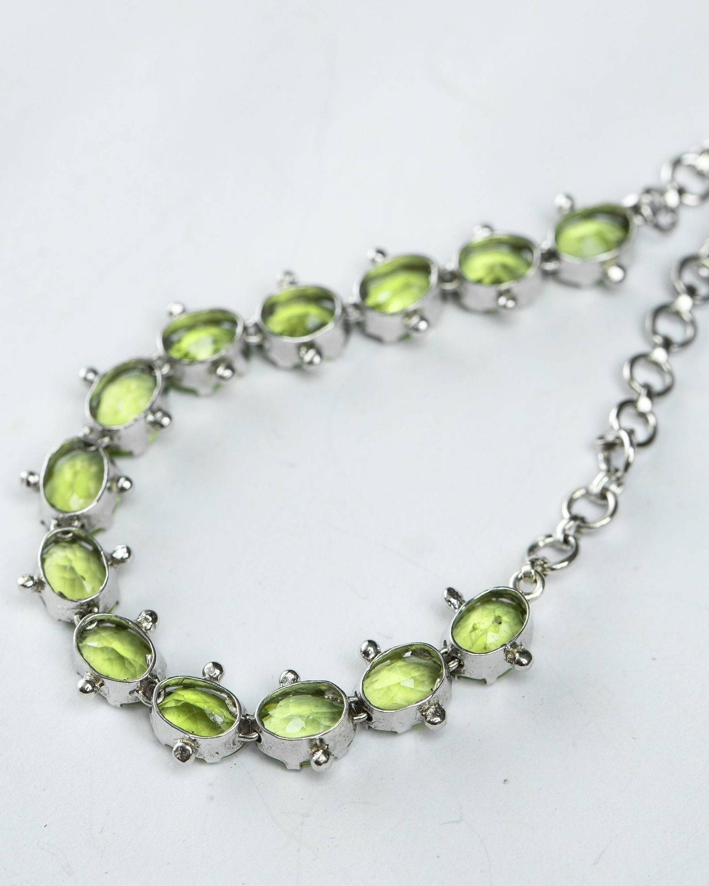 Mint Green Peridot Tennis Bracelet with oval-cut gemstones set in sterling silver. A timeless and elegant jewelry piece for any occasion.