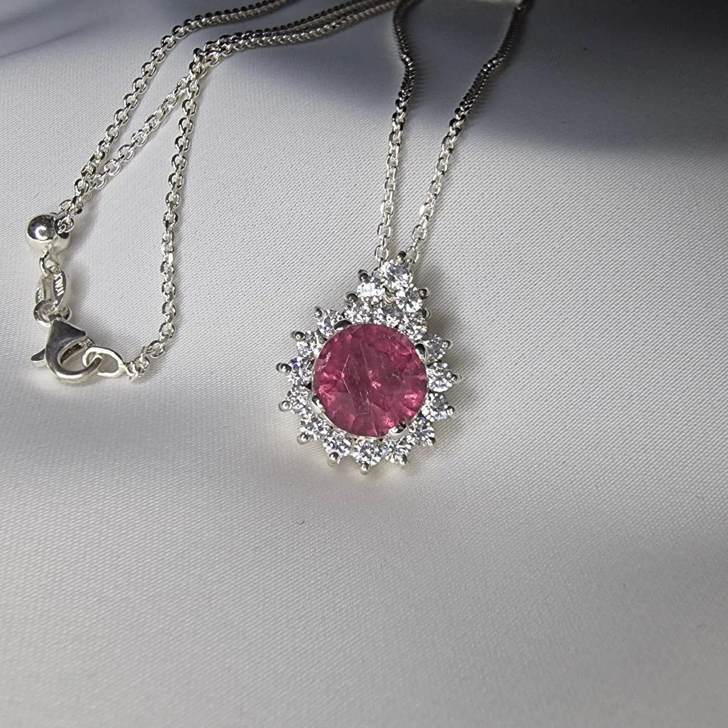 a close up of two necklaces on a white surface