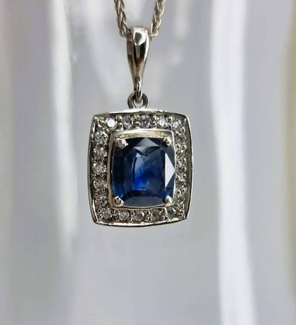 a pendant with a blue stone surrounded by diamonds