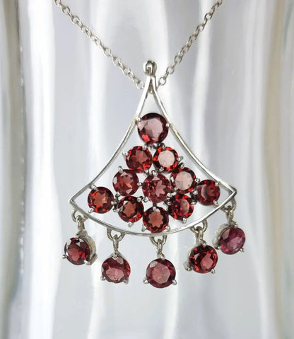 a silver necklace with red stones hanging from it