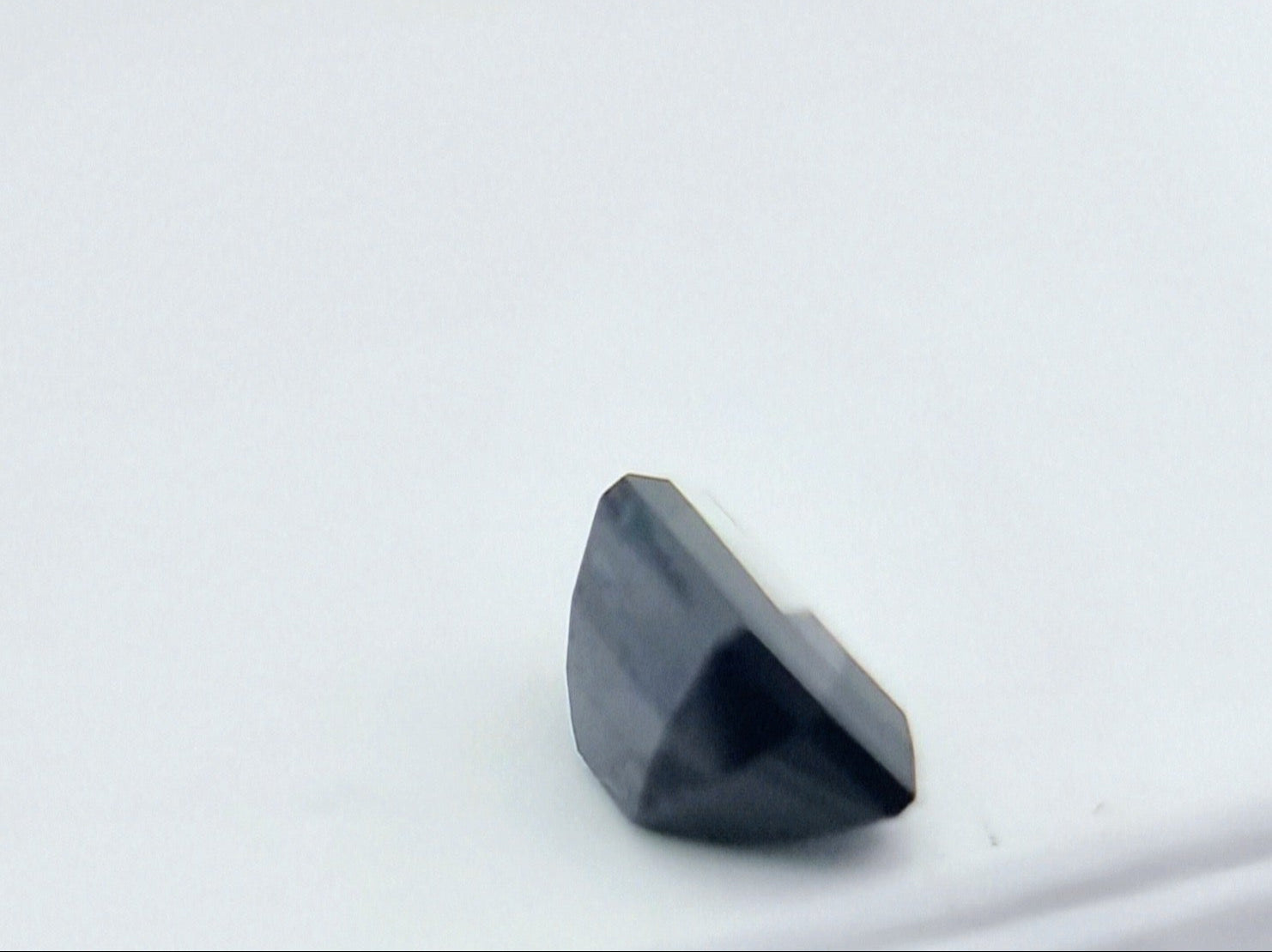 Side view of 1.84 ctw rectangular greenish blue sapphire showing its depth and precision cut, perfect for collectors and custom jewelry.
