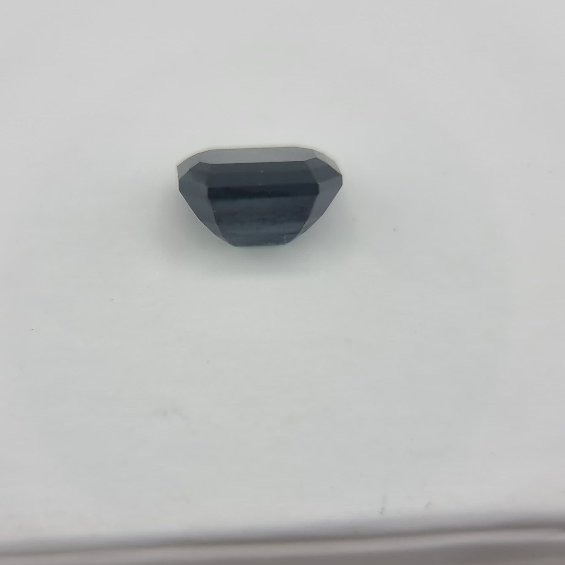 Back view of rectangular cut 1.84 ctw greenish blue sapphire, highlighting its polished facets and collectible gemstone quality.