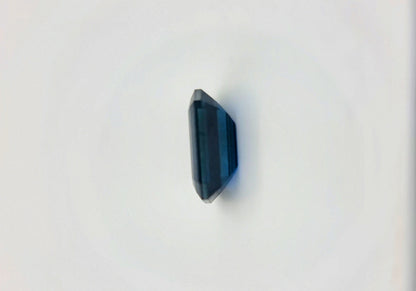 Vertical side view of 2.1ct rectangular cut dark blue natural sapphire gemstone emphasizing its thickness and geometric precision.