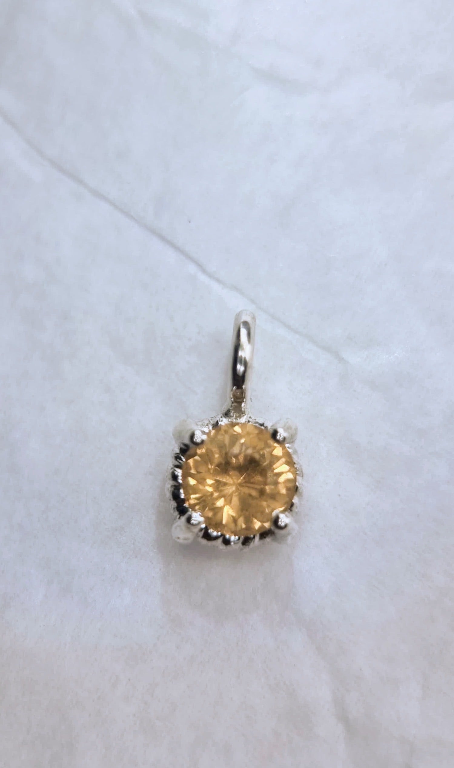 Top view of 6mm Citrine Sterling Silver Pendant without chain, emphasizing the gemstone's brilliance and twist setting.