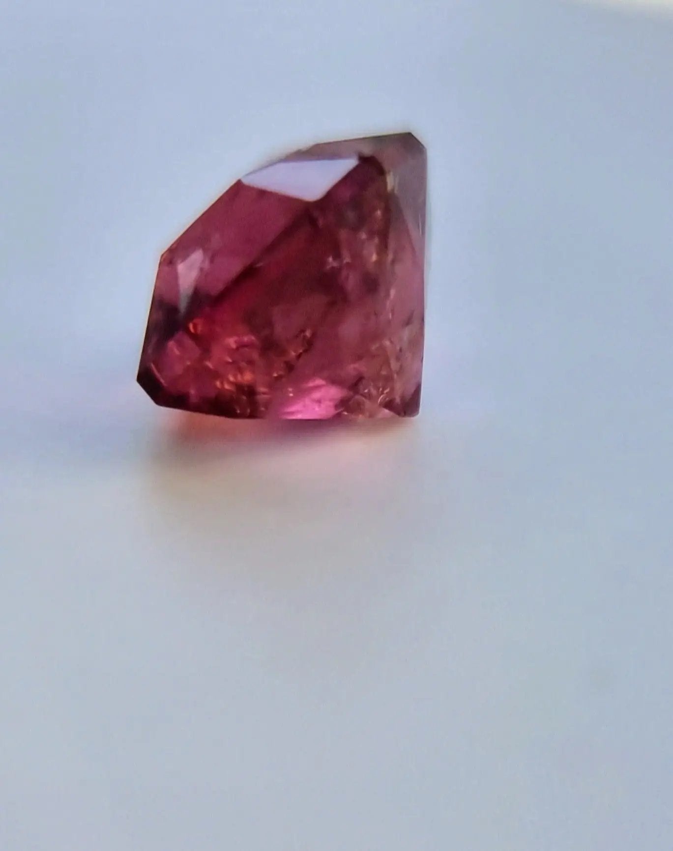 Side view of 7.42ct Pink Tourmaline Gemstone with faceted cushion cut. Deep pink clarity ideal for custom jewelry or gemstone displays.