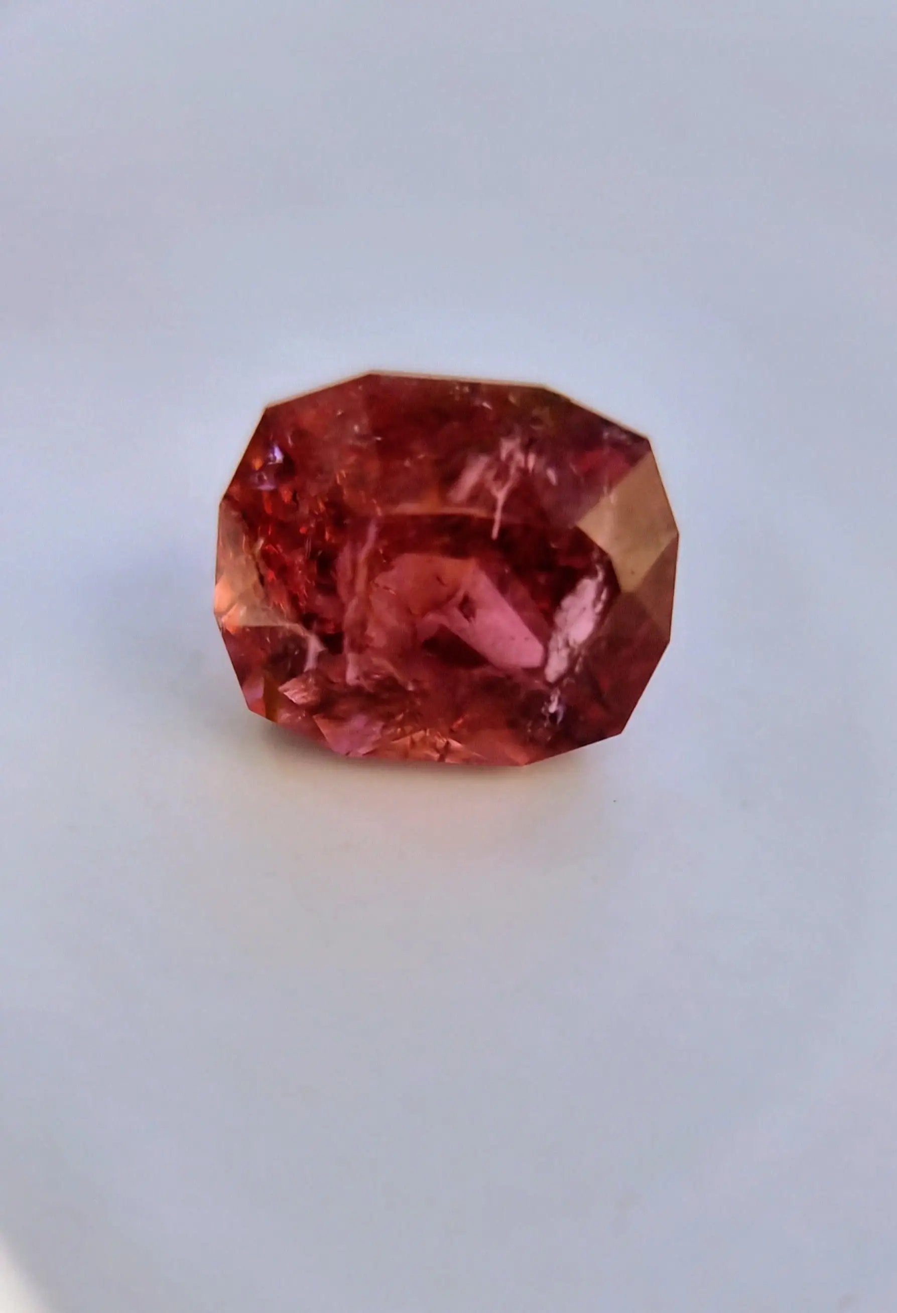 Cushion-cut 7.42ct Pink Tourmaline Gemstone glowing with warm pink and orange tones. A rare gemstone for collectors and creative artisans.