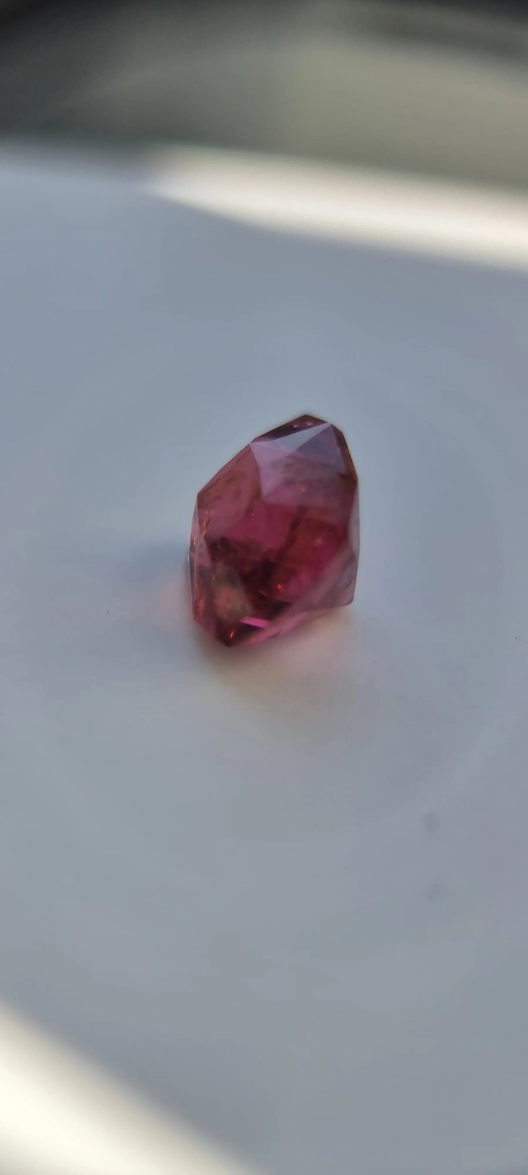 7.42ct Pink Tourmaline Gemstone in cushion cut, viewed from the side to show clarity and depth. A collectible gem with symbolic meaning.