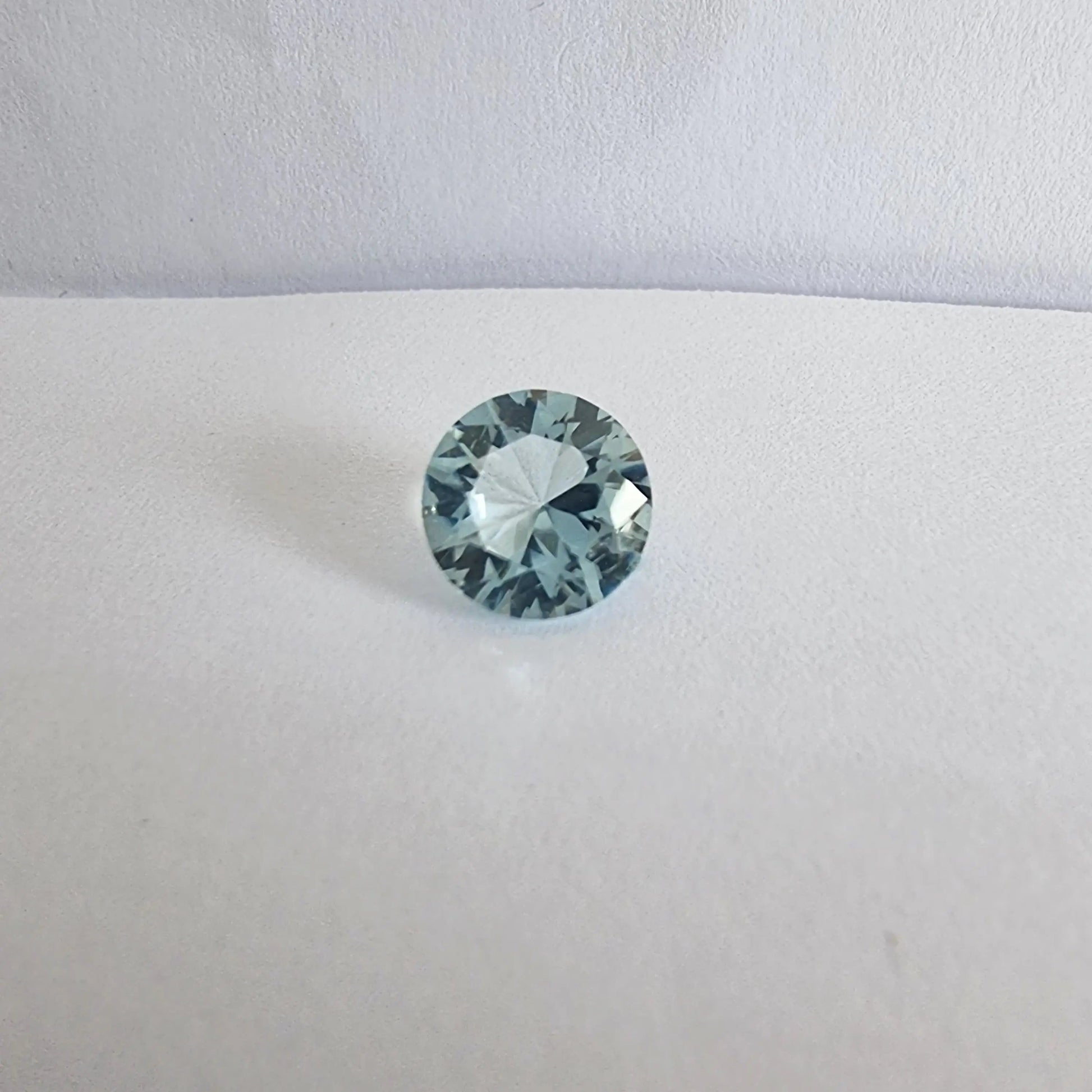 Buy Aquamarine Loose Gemstone - Premium Quality Gems featuring a round-cut aquamarine with brilliant clarity on a white background.
