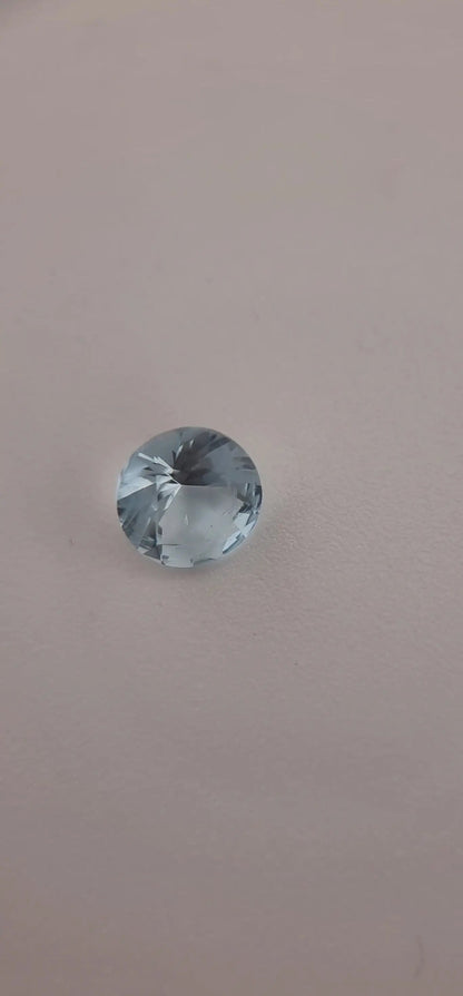 Round-cut aquamarine gemstone with icy blue color and excellent clarity, perfect for collectors and custom jewelry designs.