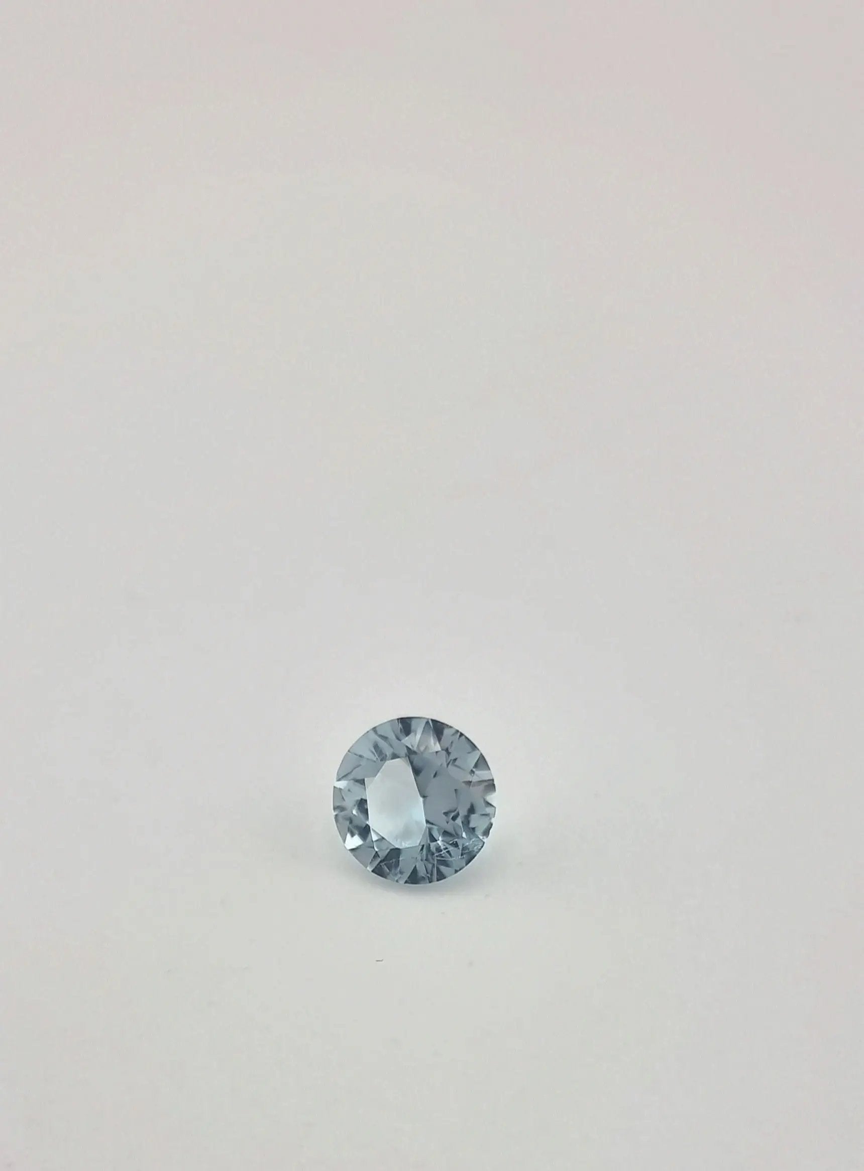 Faceted aquamarine gemstone with icy blue tone and round shape, perfect for custom jewelry or gemstone collections.