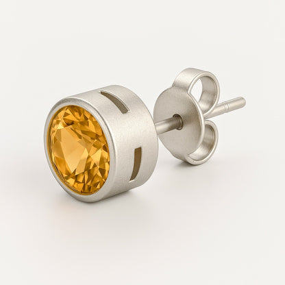 Side view of round-cut citrine stud earring in sterling silver geometric cage setting with secure post and butterfly back closure.