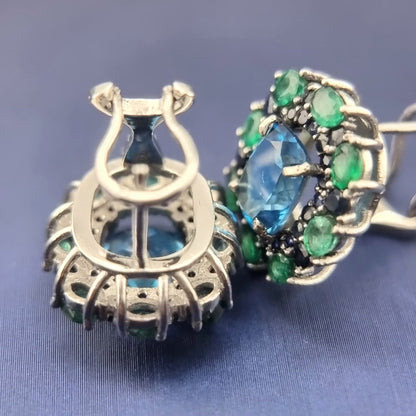 Underside of Natural Topaz Emerald & Sapphire Platinum Earrings revealing gemstone cut and platinum framework craftsmanship.