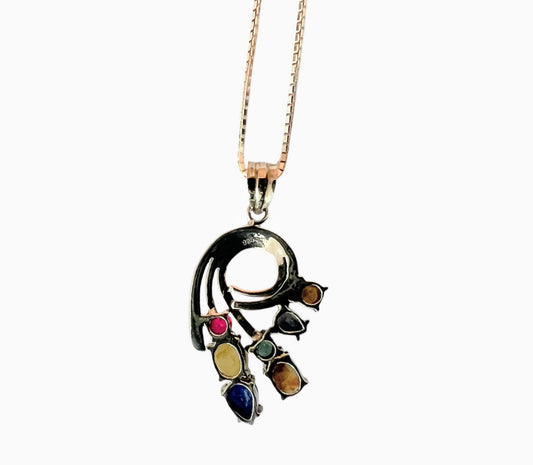 Back view of Multigem Swirling Infinity Pendant Necklace with ruby, sapphires, emerald, and cat's-eyes set in sterling silver. Detailed craftsmanship in floral design.