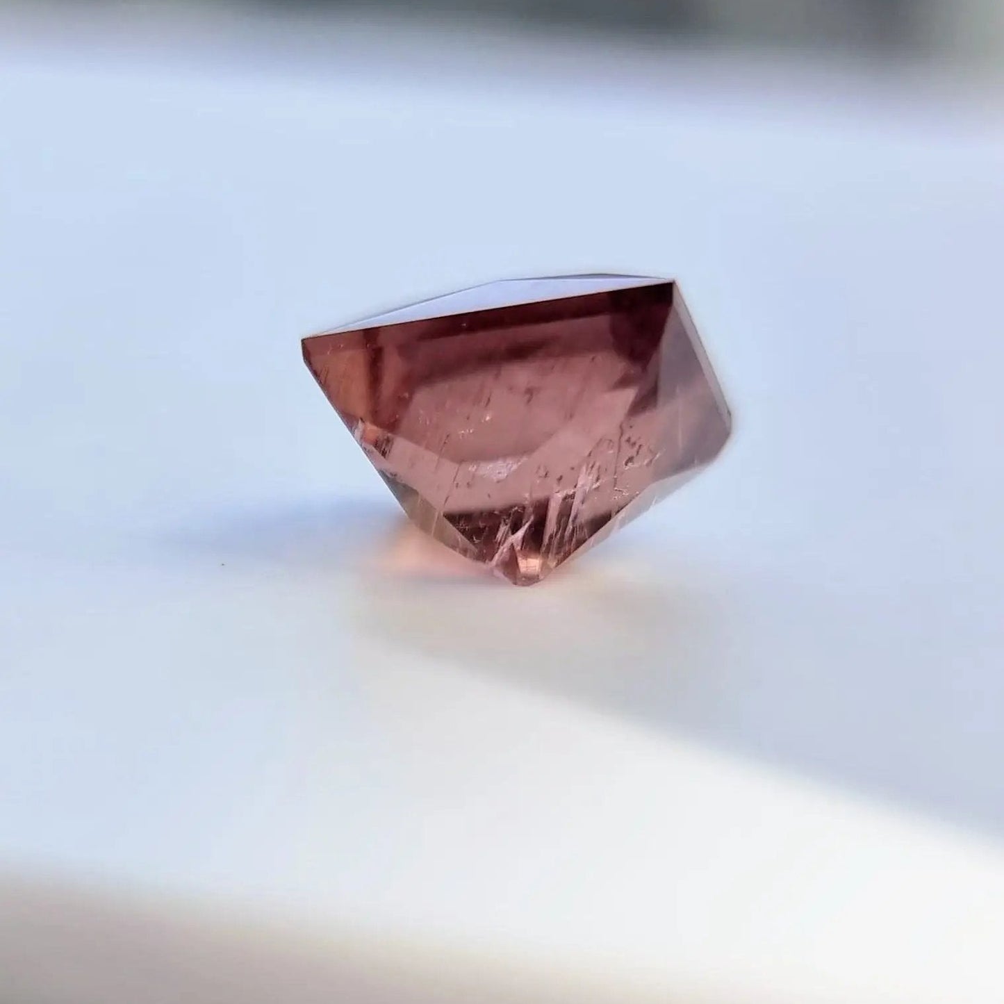 Side view of 5.13 carat rust red square cut tourmaline, showcasing its depth and precision cut for gemstone collectors.