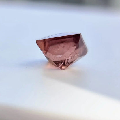 Side view of 5.13 carat rust red square cut tourmaline, showcasing its depth and precision cut for gemstone collectors.