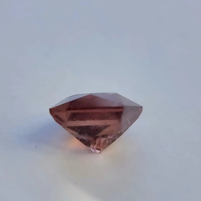 Bottom angle of square cut red tourmaline gemstone highlighting its faceted pavilion and deep red tones.