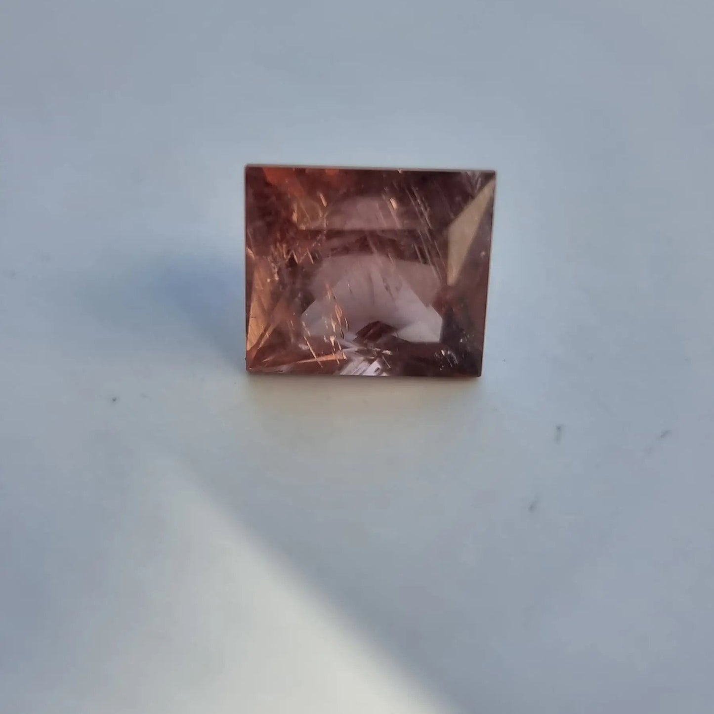 Front view of red square cut tourmaline gemstone with natural inclusions and warm autumn color, 5.13 carats.