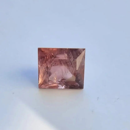 High-clarity 5.13 carat red square cut tourmaline with unique internal patterns, perfect for gemstone collectors.