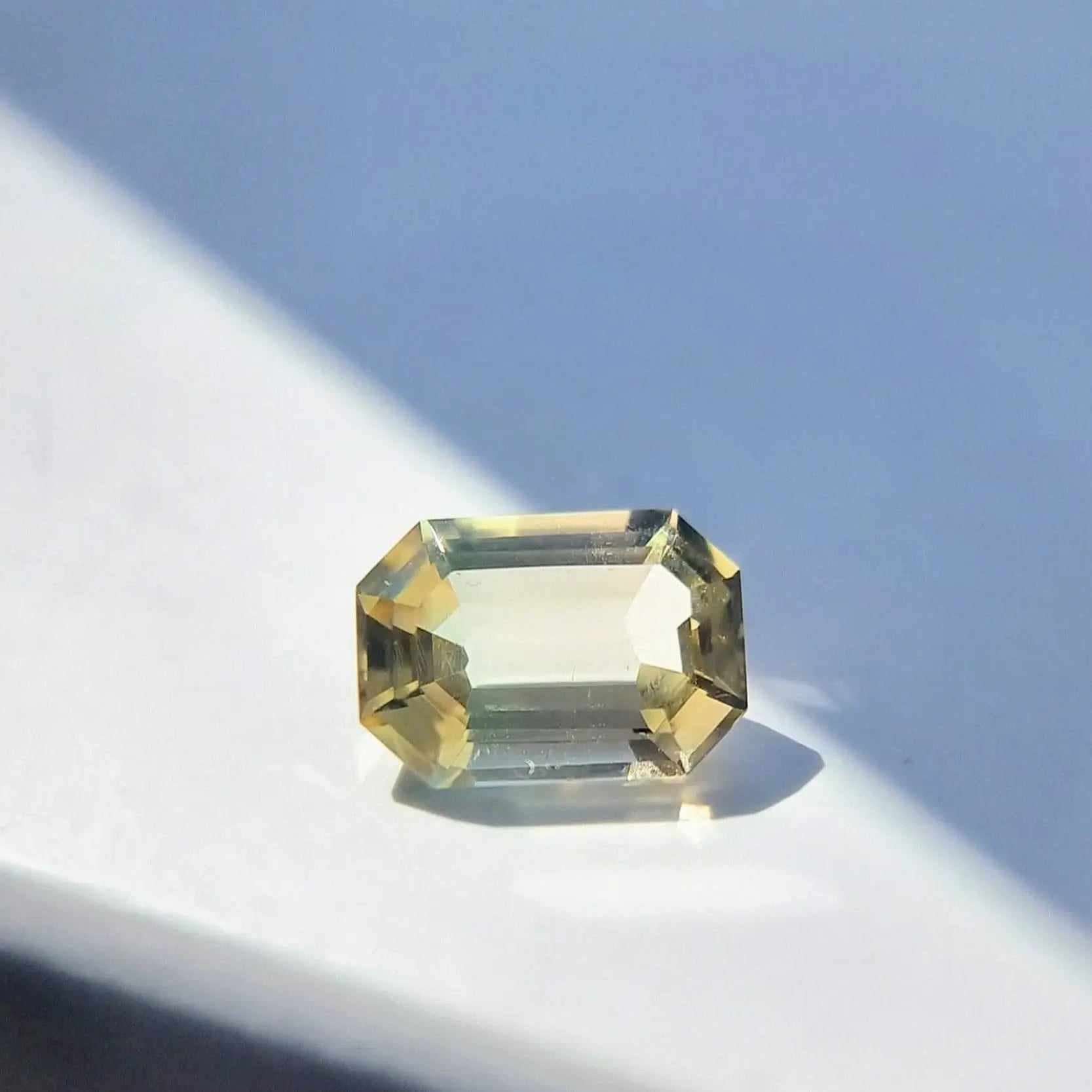 Sunlit 6.1ct bi-color tourmaline in emerald cut, showcasing natural untreated clarity and dual-tone color play.