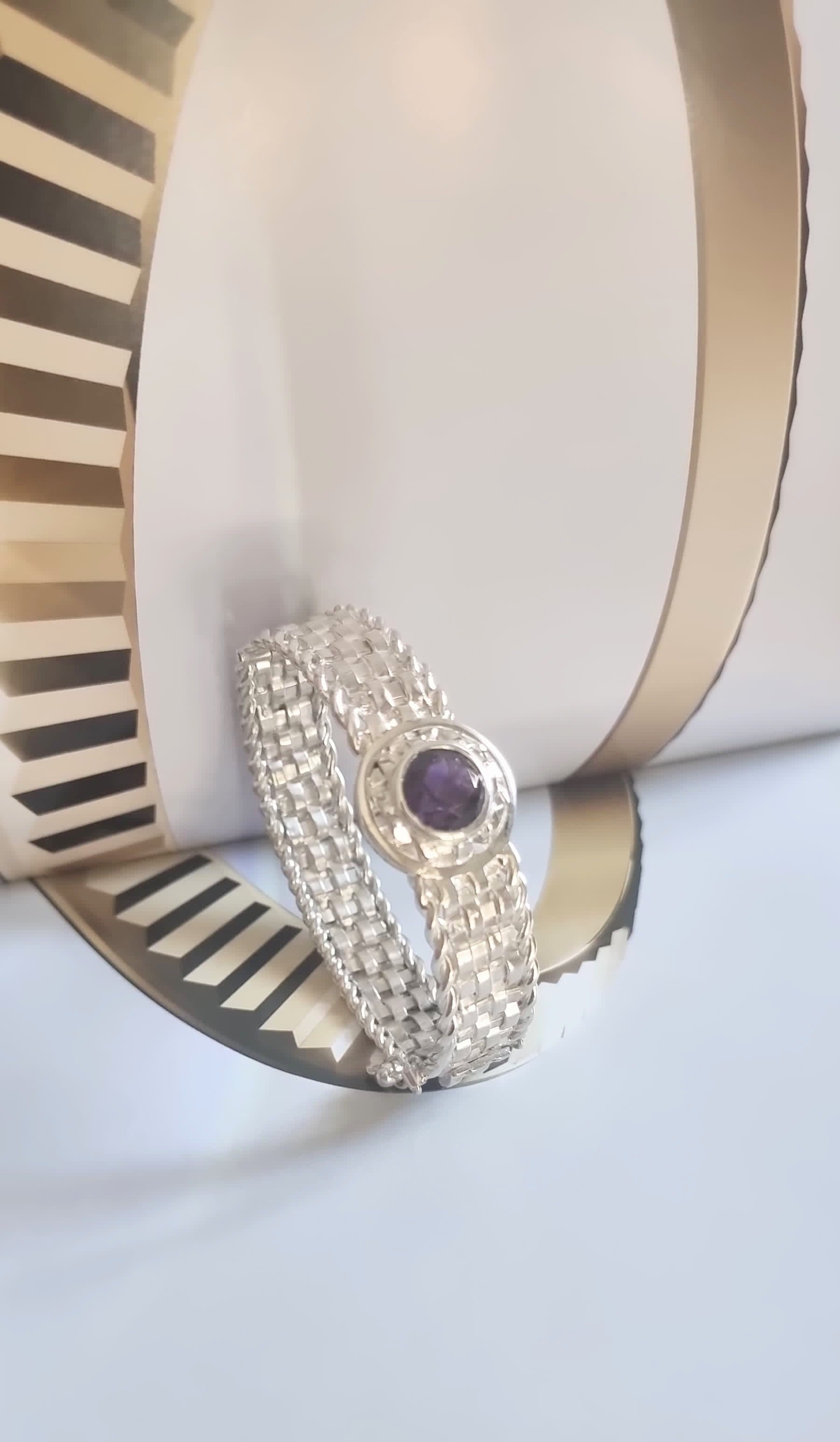 Handmade Basotho Bracelet in Rhodium Plated Silver displayed artistically with gold accents, highlighting its amethyst birthstone. Unique Jewelry - Hannaboya Jewelry.