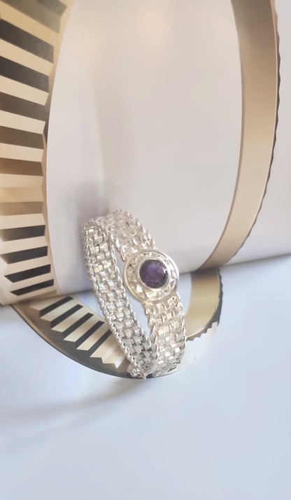Handmade Basotho Bracelet in Rhodium Plated Silver displayed artistically with gold accents, highlighting its amethyst birthstone. Unique Jewelry - Hannaboya Jewelry.