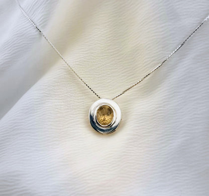 Sterling silver necklace with a natural citrine pendant, styled on a soft white surface to highlight its refined and timeless appeal.