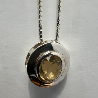 Close-up of citrine pendant necklace in sterling silver with a faceted gemstone, emphasizing the handcrafted bezel and polished finish.