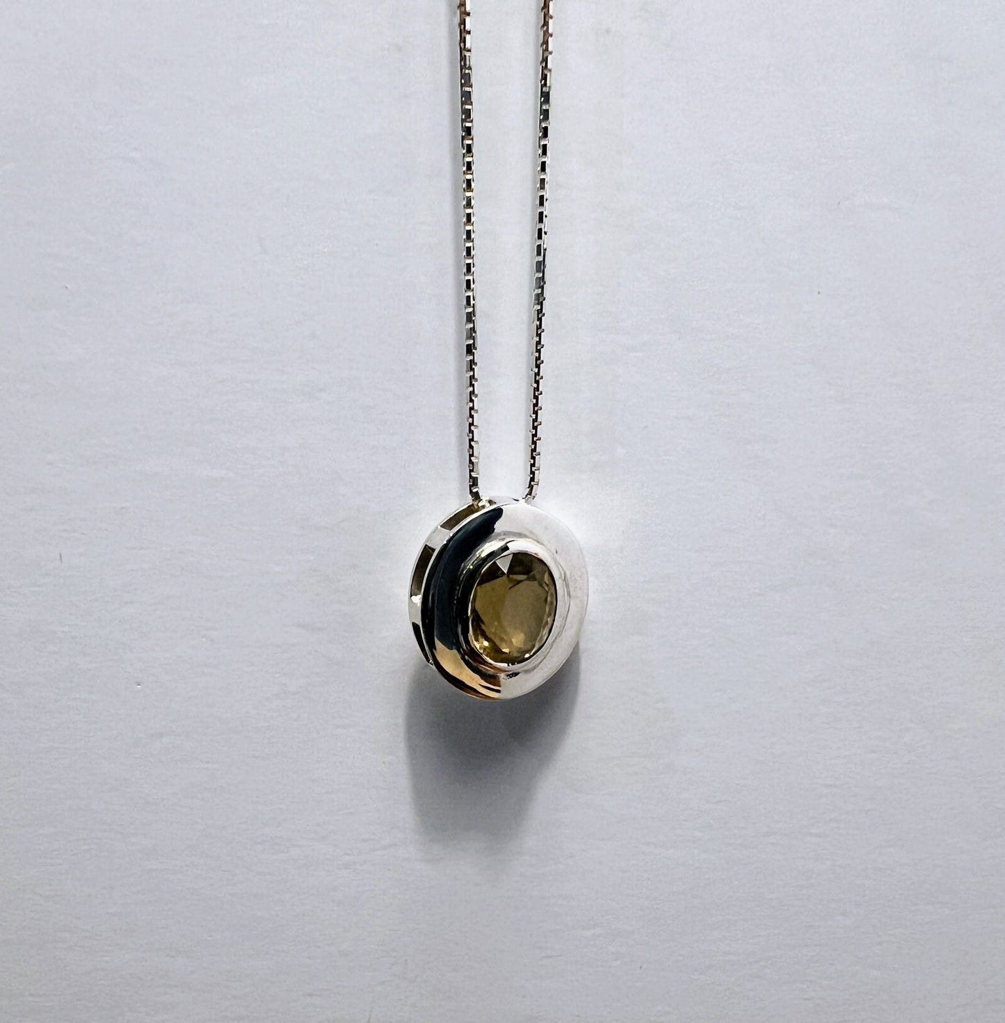Elegant citrine pendant necklace in sterling silver with a round gemstone, suspended on a box chain for a sophisticated jewelry statement.
