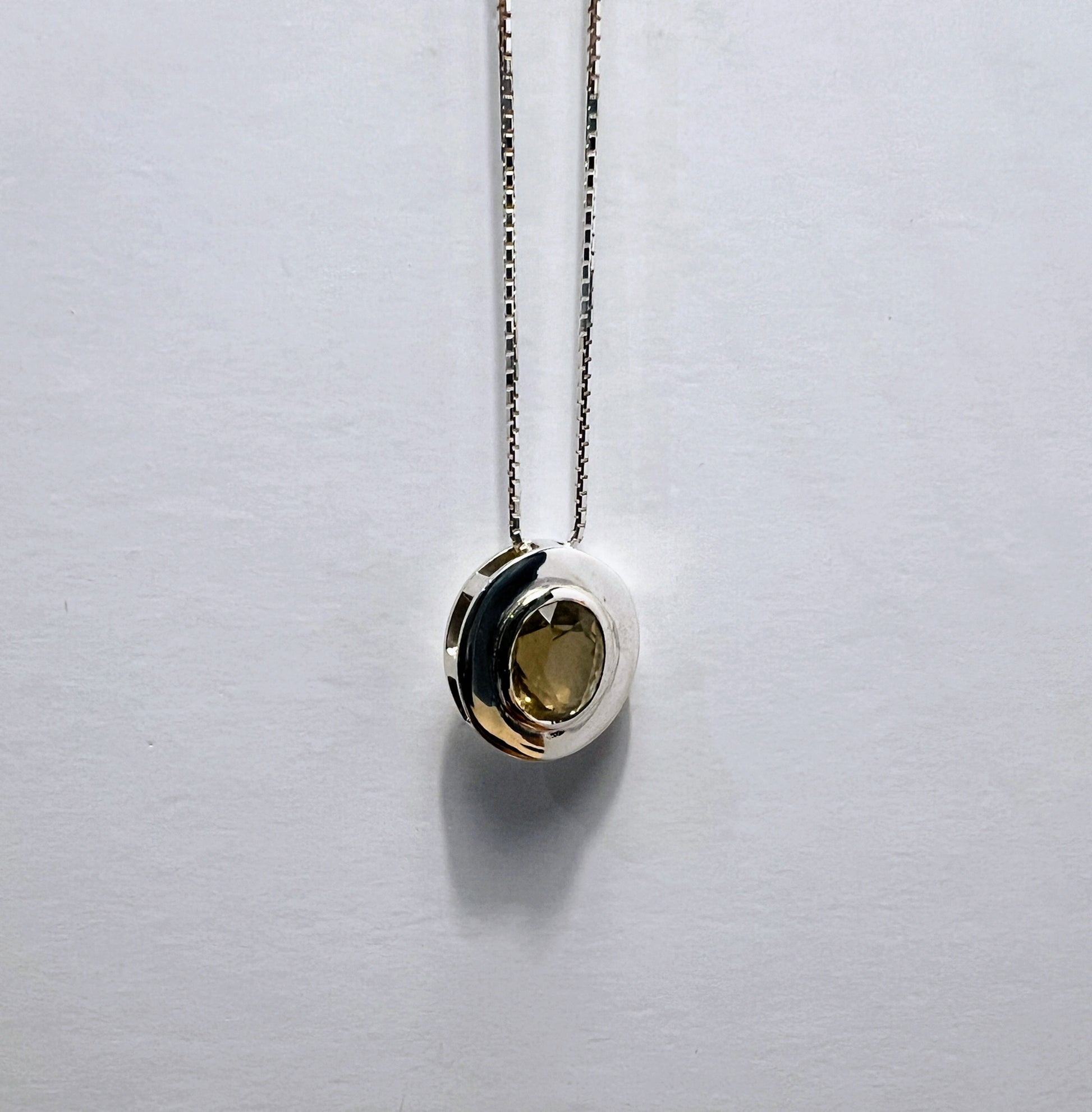 Elegant citrine pendant necklace in sterling silver with a round gemstone, suspended on a box chain for a sophisticated jewelry statement.