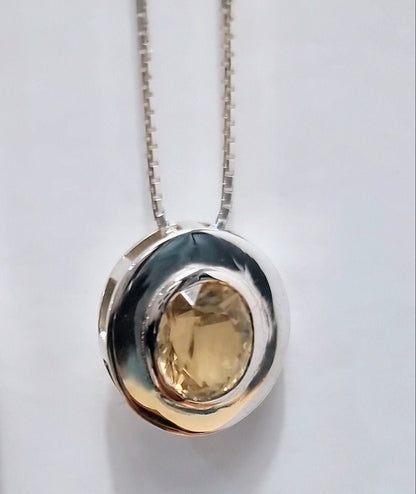 Detailed view of citrine pendant necklace in sterling silver featuring a faceted natural gemstone in a modern circular bezel setting.